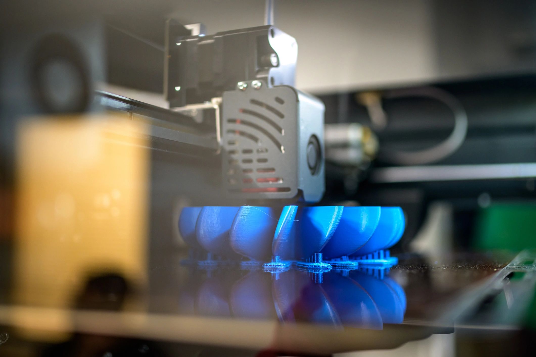 Close-up view of 3D printing complicated plastic part from blue filament