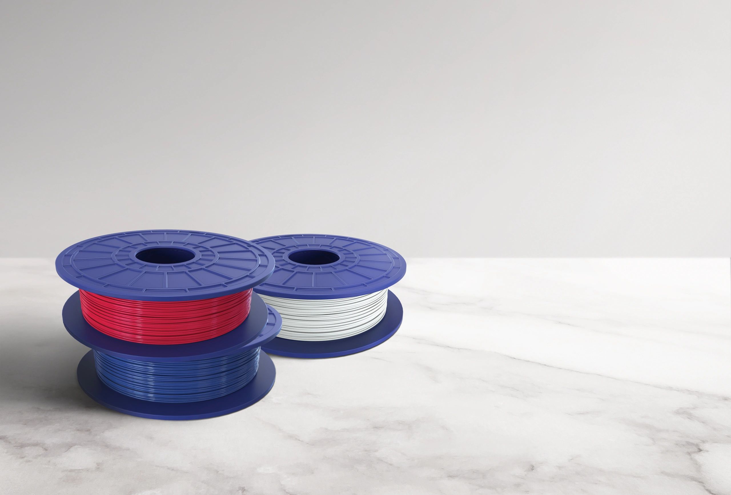 Multicolored 3D printer filament spools on a countertop